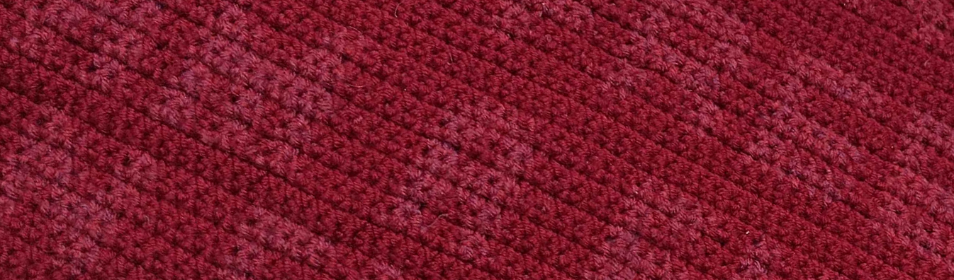 site banner, image of a red piece of crochet with low contrast cropped text