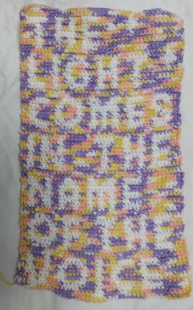 a rectangular, portrait piece of crochet. there is white text which says 'the light comes in the name of the voice'. the background is purple, yellow pink and white.